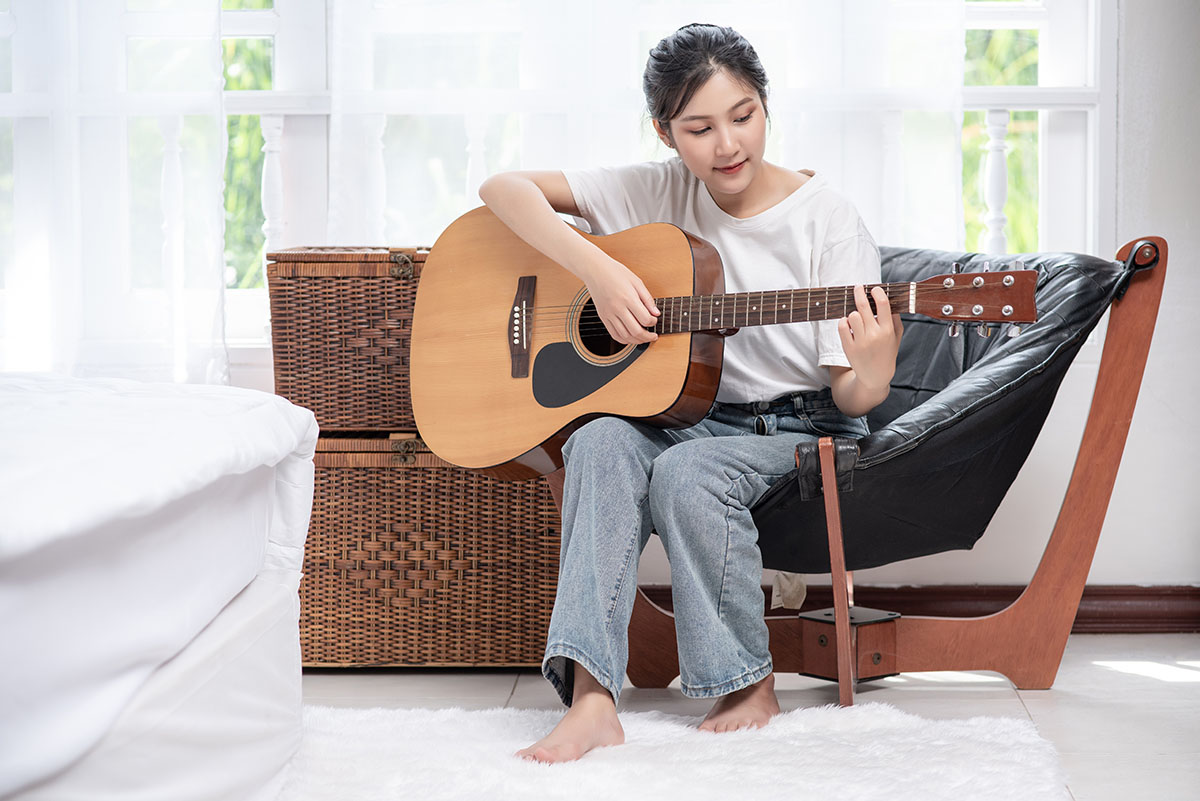 The Girl Is Sitting And Playing The Guitar On The S2y6hur.jpg